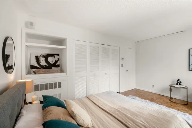 a bedroom with a bed a mirror and lamp