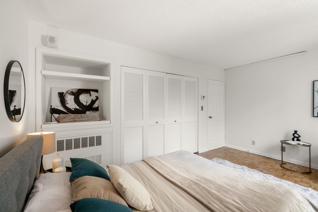 33 Pond Avenue, Unit 523 Brookline, MA 02445 - Photo 16 of 31 a bedroom with a bed a mirror and lamp