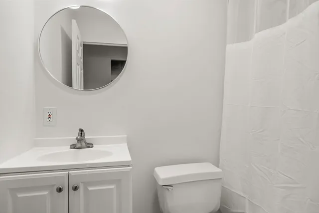 a bathroom with a toilet a sink and mirror