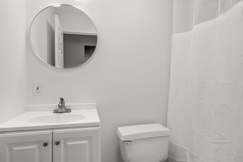 33 Pond Avenue, Unit 523 Brookline, MA 02445 - Photo 17 of 31 a bathroom with a toilet a sink and mirror
