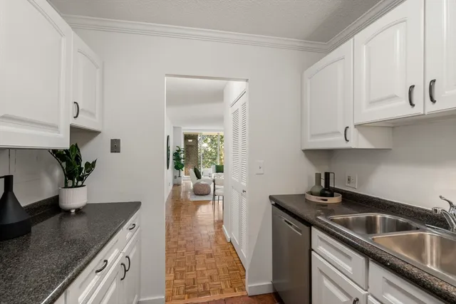 a kitchen with granite countertop a sink stove and cabinets