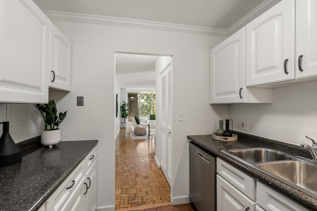 33 Pond Avenue, Unit 523 Brookline, MA 02445 - Photo 5 of 31 a kitchen with granite countertop a sink stove and cabinets
