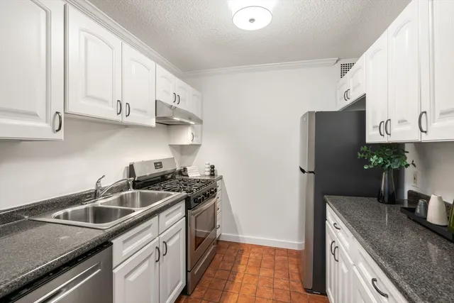 a kitchen with stainless steel appliances granite countertop a sink stove and refrigerator