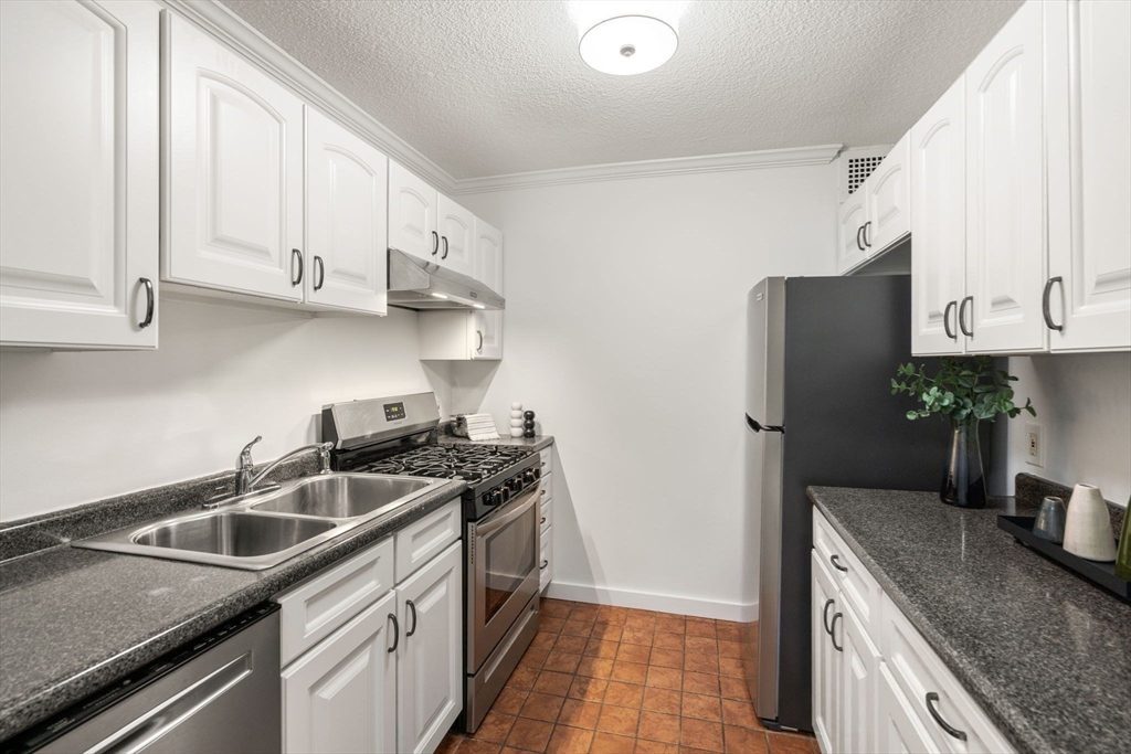 33 Pond Avenue, Unit 523 Brookline, MA 02445 - Photo 7 of 31 a kitchen with stainless steel appliances granite countertop a sink stove and refrigerator