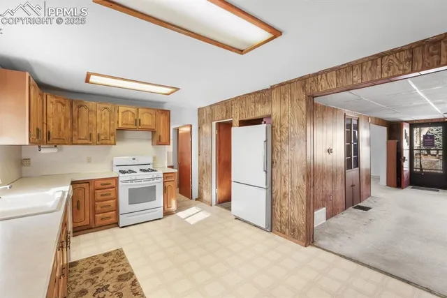 a kitchen with stainless steel appliances granite countertop a stove a sink and a refrigerator