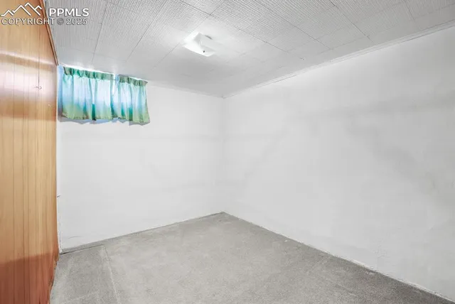 an empty room with windows and chandelier fan