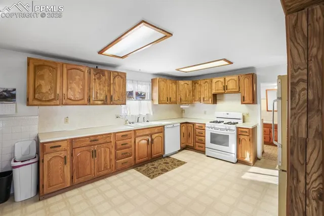 a large kitchen with stainless steel appliances granite countertop a stove sink and cabinets