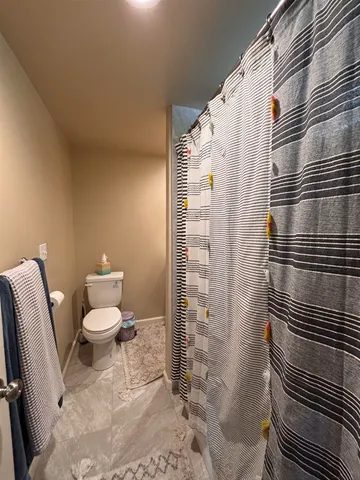 a bathroom with a toilet and a shower