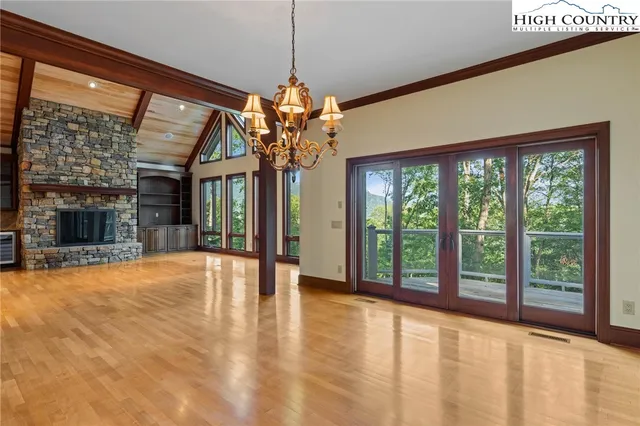 a view of a room with wooden floor fireplace and windows
