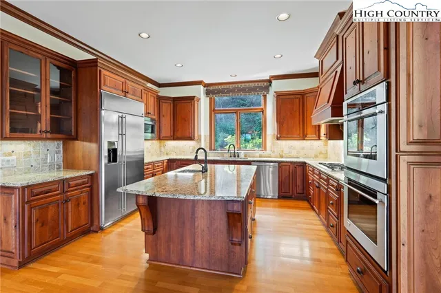 a kitchen with stainless steel appliances granite countertop a sink and a stove