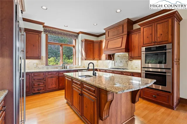 a kitchen with stainless steel appliances granite countertop a sink stove and refrigerator