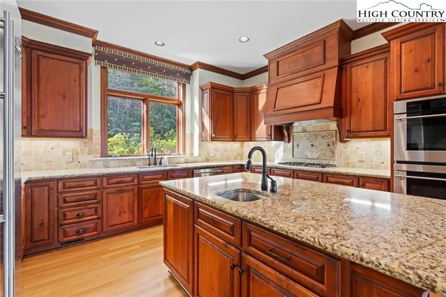 a kitchen with stainless steel appliances granite countertop a sink stove and cabinets