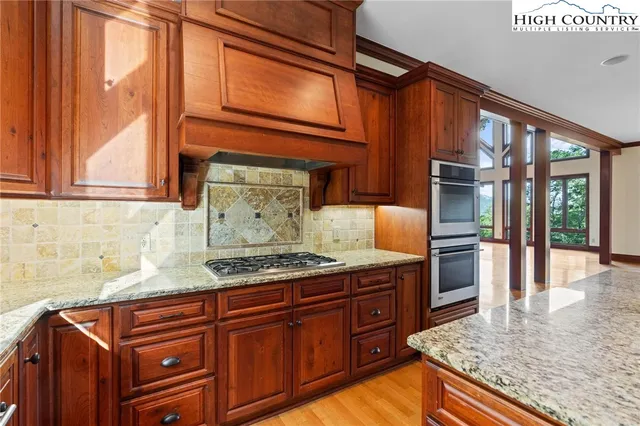 a kitchen with stainless steel appliances granite countertop wooden cabinets a oven and granite counter tops