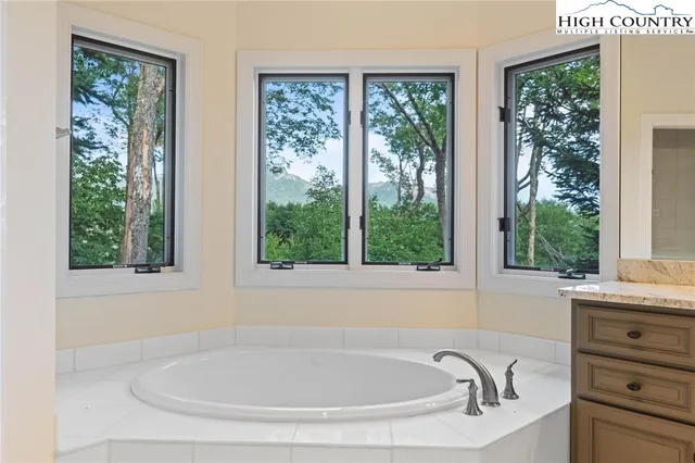 a white bath tub sitting in a bathroom next to a window