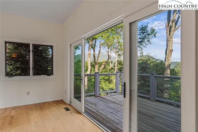 a view of a room that has wooden floor and large window