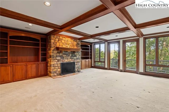 a view of an empty room with a fireplace and a window