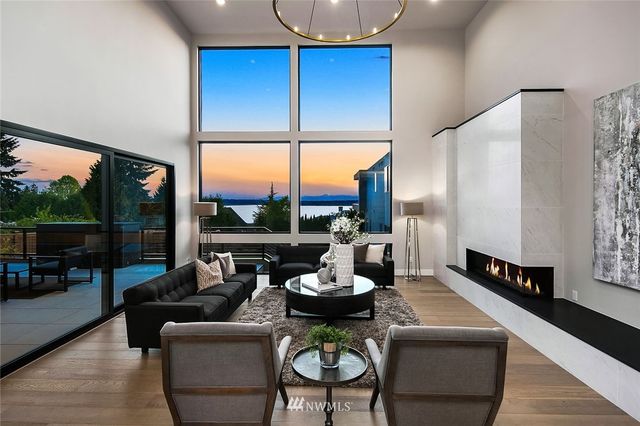 a living room with furniture fireplace and large windows