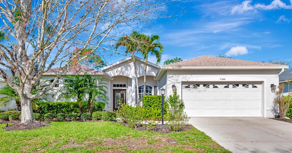 7344 Arrowhead Run Lakewood Ranch, FL 34202 - Photo 1 of 24 a front view of a house with a garden