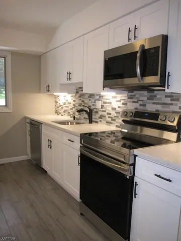 a kitchen with stainless steel appliances a stove a microwave sink and cabinets