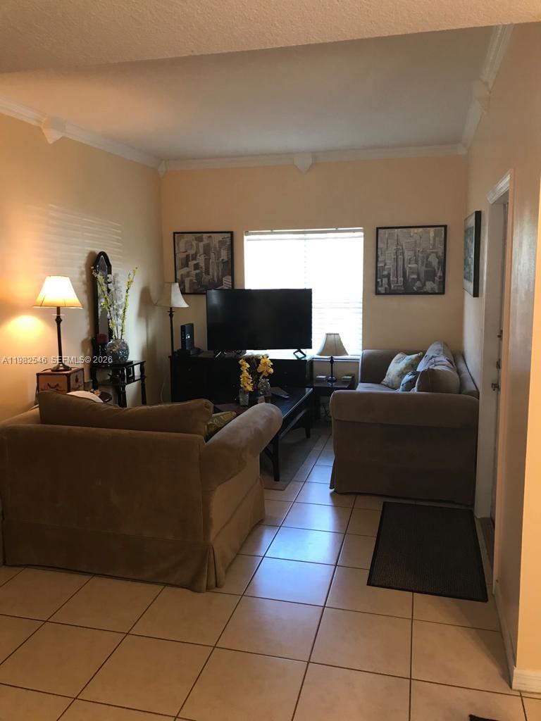 2142 Siena Way Hollywood, FL 33021 - Photo 2 of 13 a living room with furniture and a flat screen tv