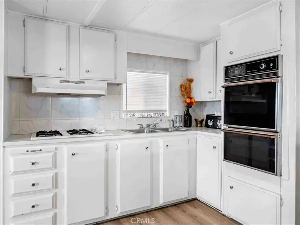 a kitchen with white cabinets and appliances