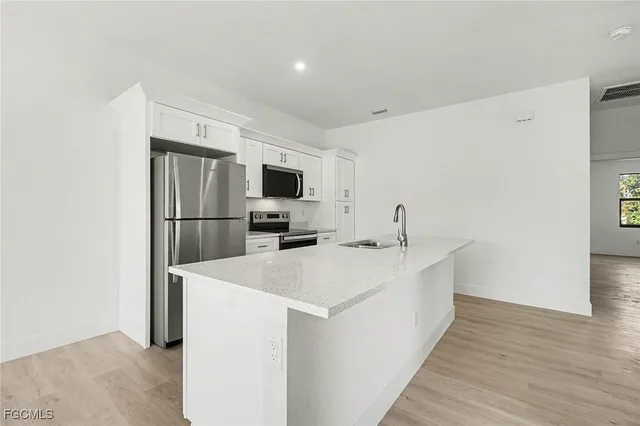 a view of empty room with wooden floor and cabinets