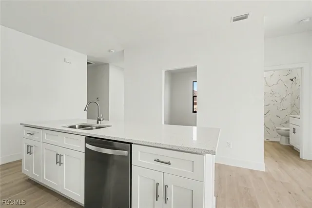 a bathroom with a granite countertop toilet and a sink