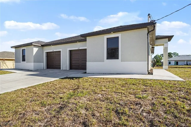 a kitchen with stainless steel appliances a stove top oven a sink a refrigerator white cabinets and wooden floor