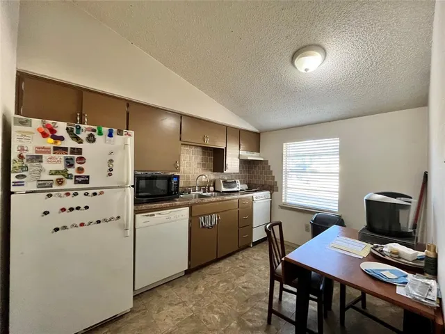 a kitchen with cabinets and white appliances