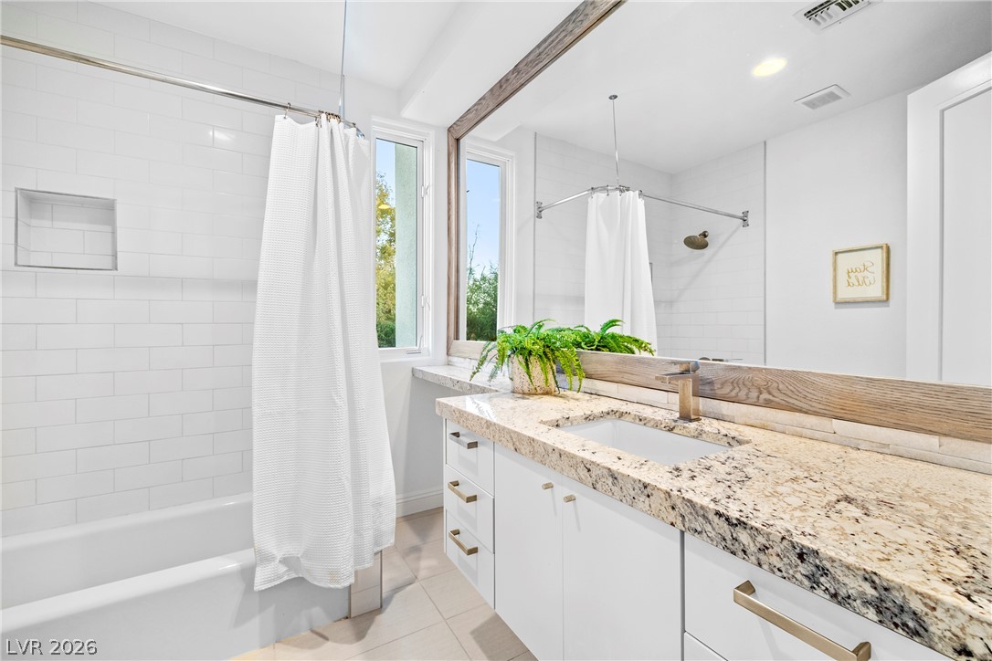 2000 Grouse Street Las Vegas, NV 89134 - Photo 33 of 89 A well-appointed bathroom with natural light, featuring a vanity and a shower-tub combination.