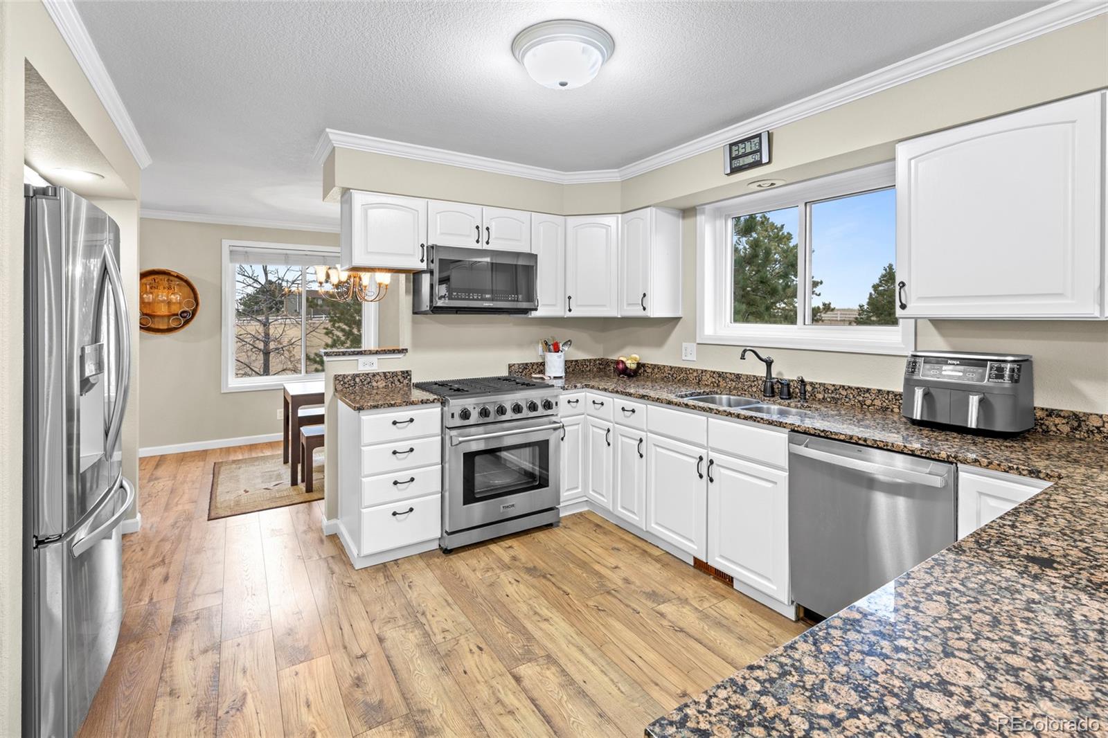 42865 Vista Ridge Road Parker, CO 80138 - Photo 12 of 50 a kitchen with stainless steel appliances kitchen island granite countertop a stove top oven a sink a counter top space and cabinets