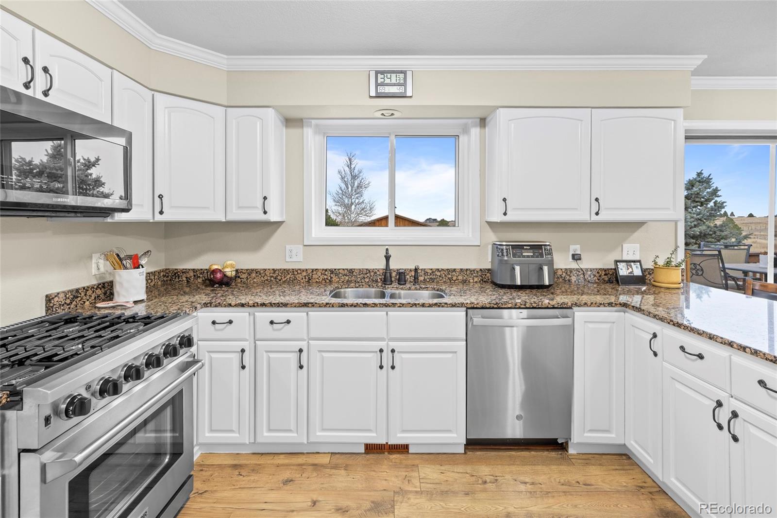 42865 Vista Ridge Road Parker, CO 80138 - Photo 14 of 50 a kitchen with granite countertop a stove sink and cabinets