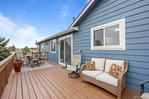 a view of a patio with couches and potted plants with wooden floor