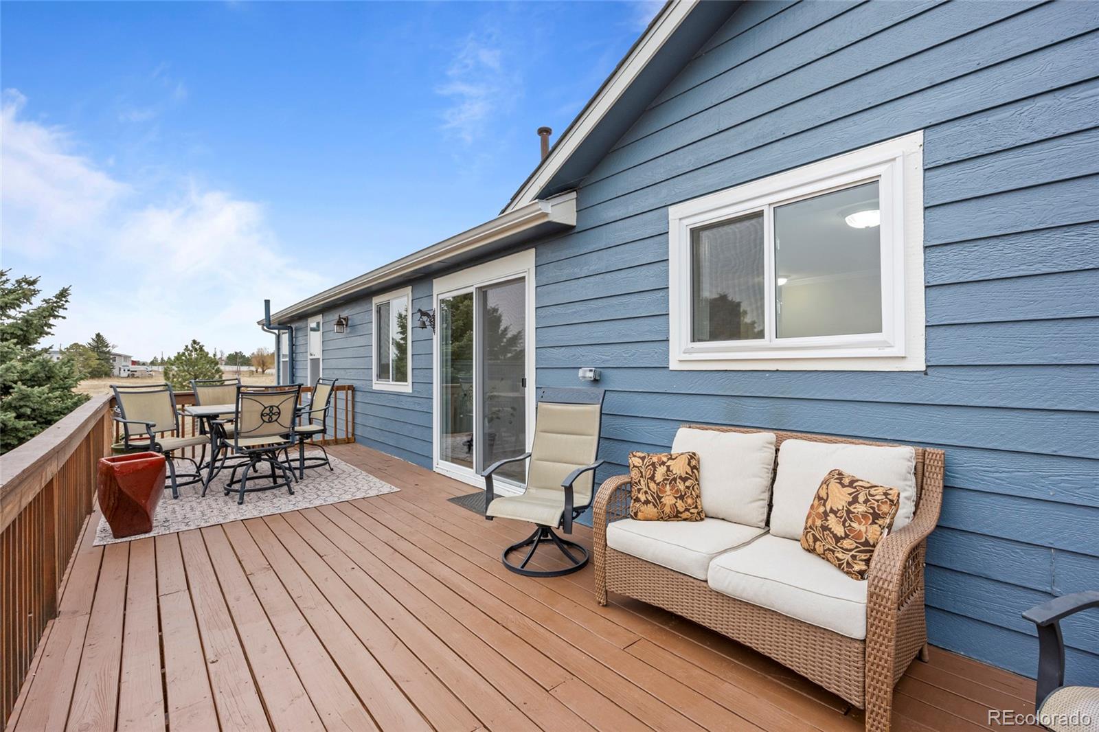 42865 Vista Ridge Road Parker, CO 80138 - Photo 16 of 50 a view of a patio with couches and potted plants with wooden floor