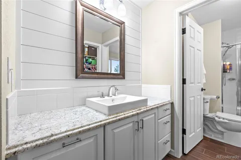 a bathroom with a granite countertop sink and a mirror