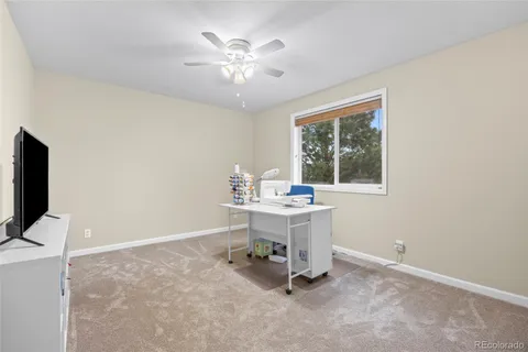 a view of a workspace with furniture and a window