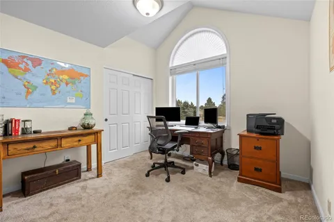 a view of a workspace with furniture and a window