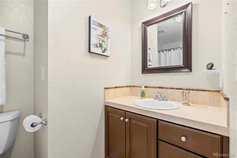 a bathroom with a sink vanity and toilet