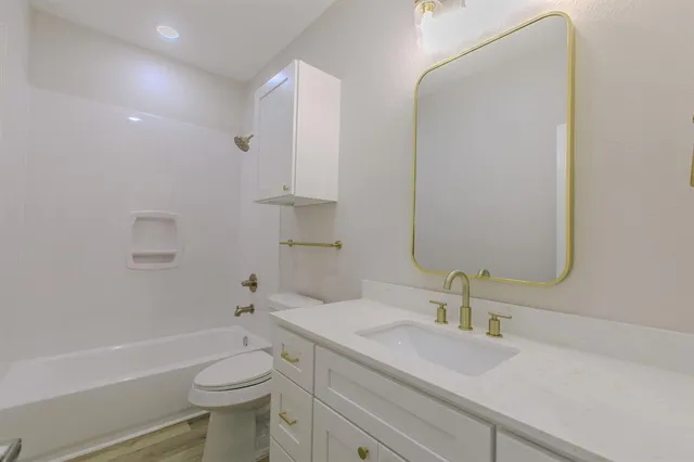 a bathroom with a sink a toilet and a mirror
