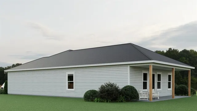 a view of a white house next to a yard with potted plants