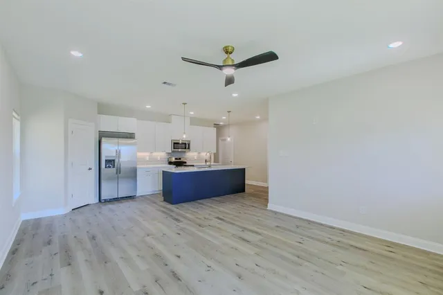 a kitchen with stainless steel appliances kitchen island wooden floors and wooden cabinets