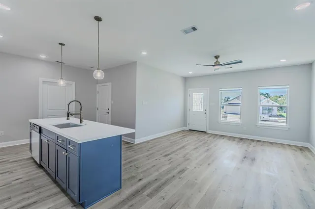 a view of a kitchen sink a center island with wooden floor