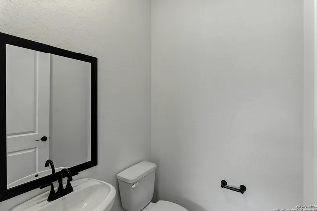 a bathroom with a toilet a sink and mirror