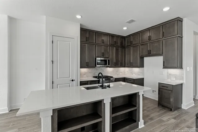 a kitchen with kitchen island a sink appliances and cabinets