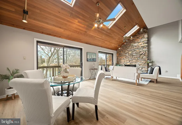 a kitchen with stainless steel appliances kitchen island granite countertop a table chairs in it and wooden floors