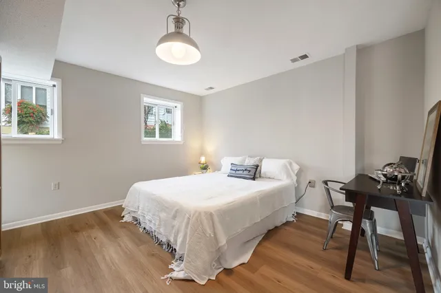 a view of a house with large tree next to a yard