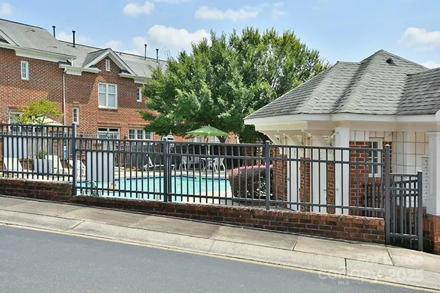 a view of a brick house with a small yard and plants
