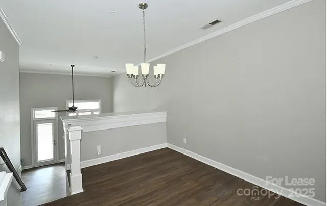 a view of a room with wooden floor and chandelier