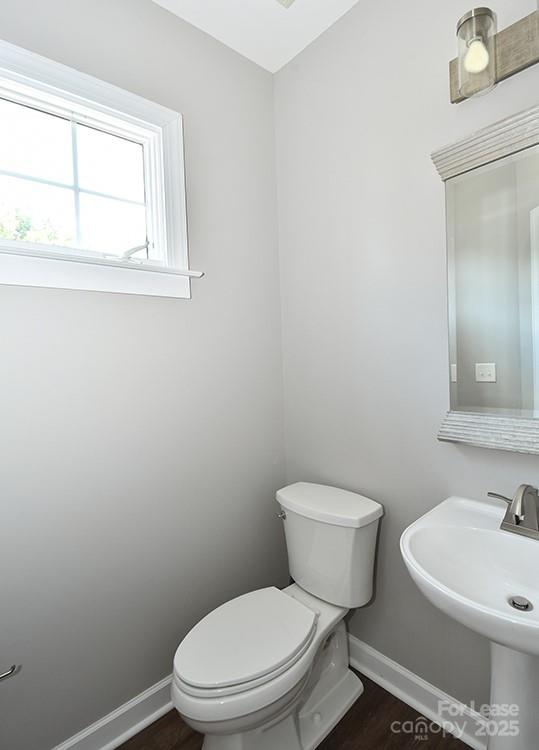 4939 South Hill View Drive Charlotte, NC 28210 - Photo 10 of 24 a white toilet sitting next to a bathroom sink