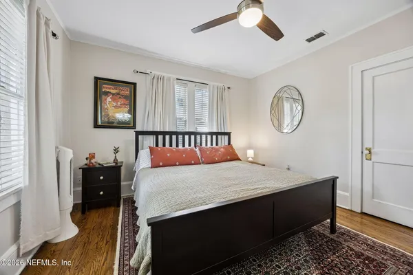 a bedroom with a bed and wooden floor